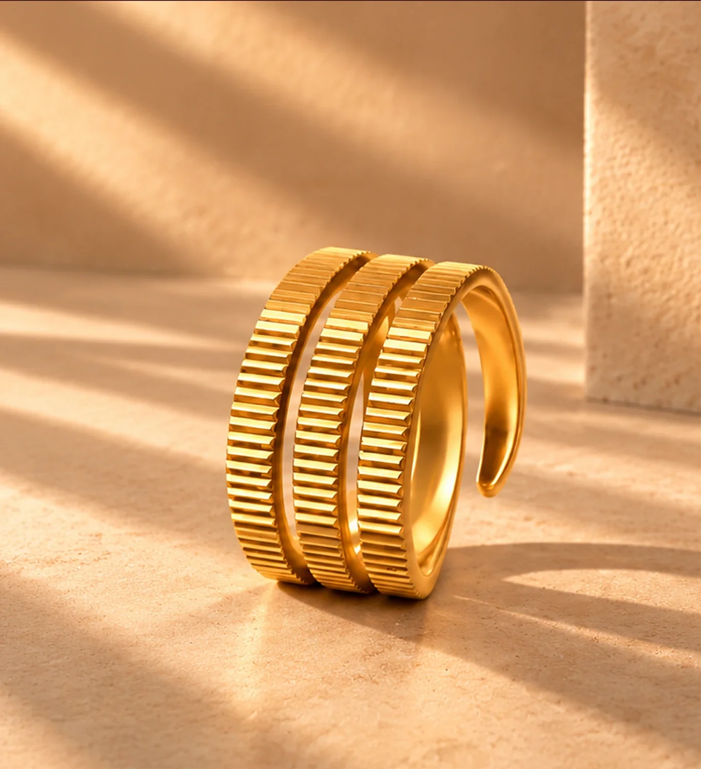 Sculptural yellow gold rings in warm sunlight